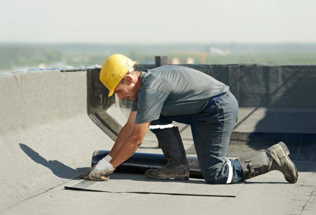 Roofer Carrying Out A Flat Roof Installation