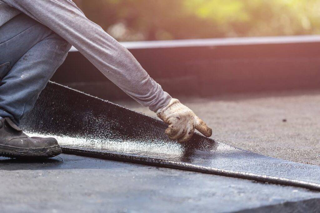 roofer laying flat roofing